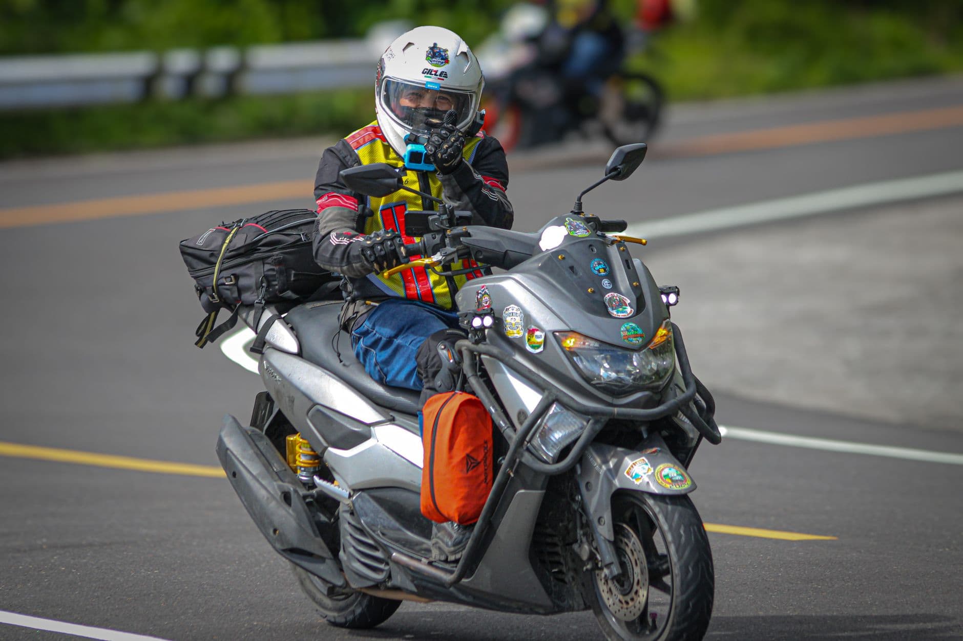 Image illustrating: A motorcyclist riding on a Walloon regional road in daylight with visible safety (editorial)