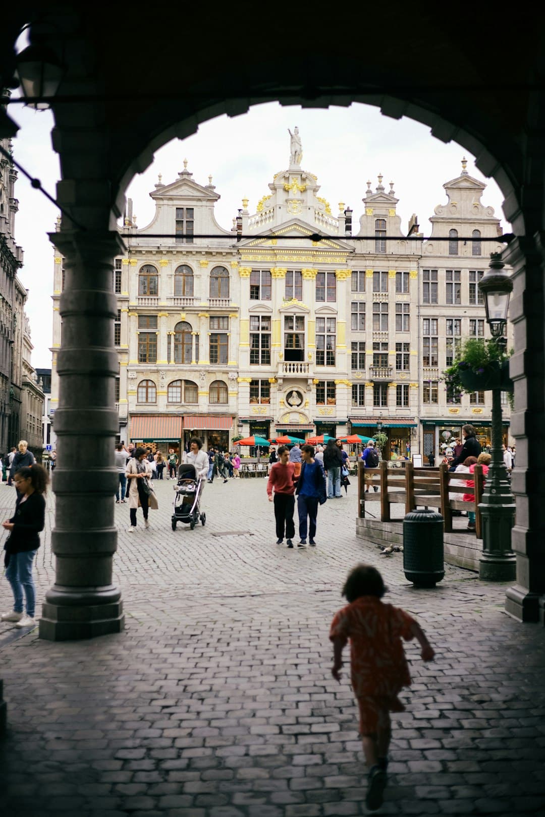 Image illustrating: People walking through central Brussels in hot summer weather under a yellow hea (editorial)