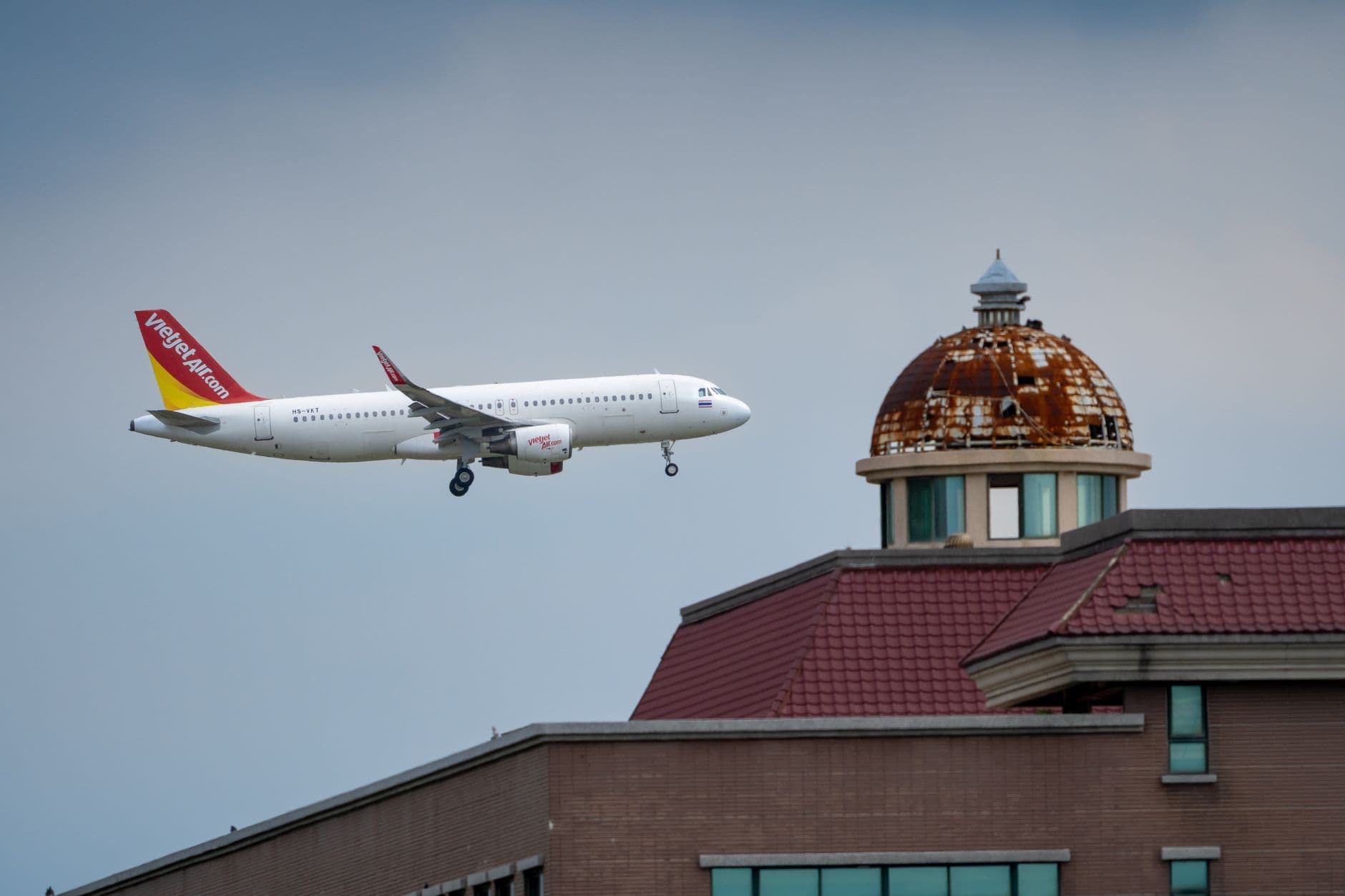 Image illustrating: Aircraft flying over dense Brussels rooftops near the Brussels Airport approach (editorial)