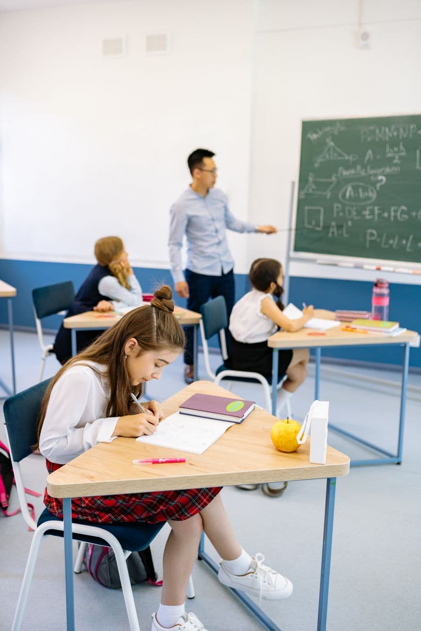 Image illustrating: A calm Flemish primary-school classroom with pupils working at desks and a teach (editorial)