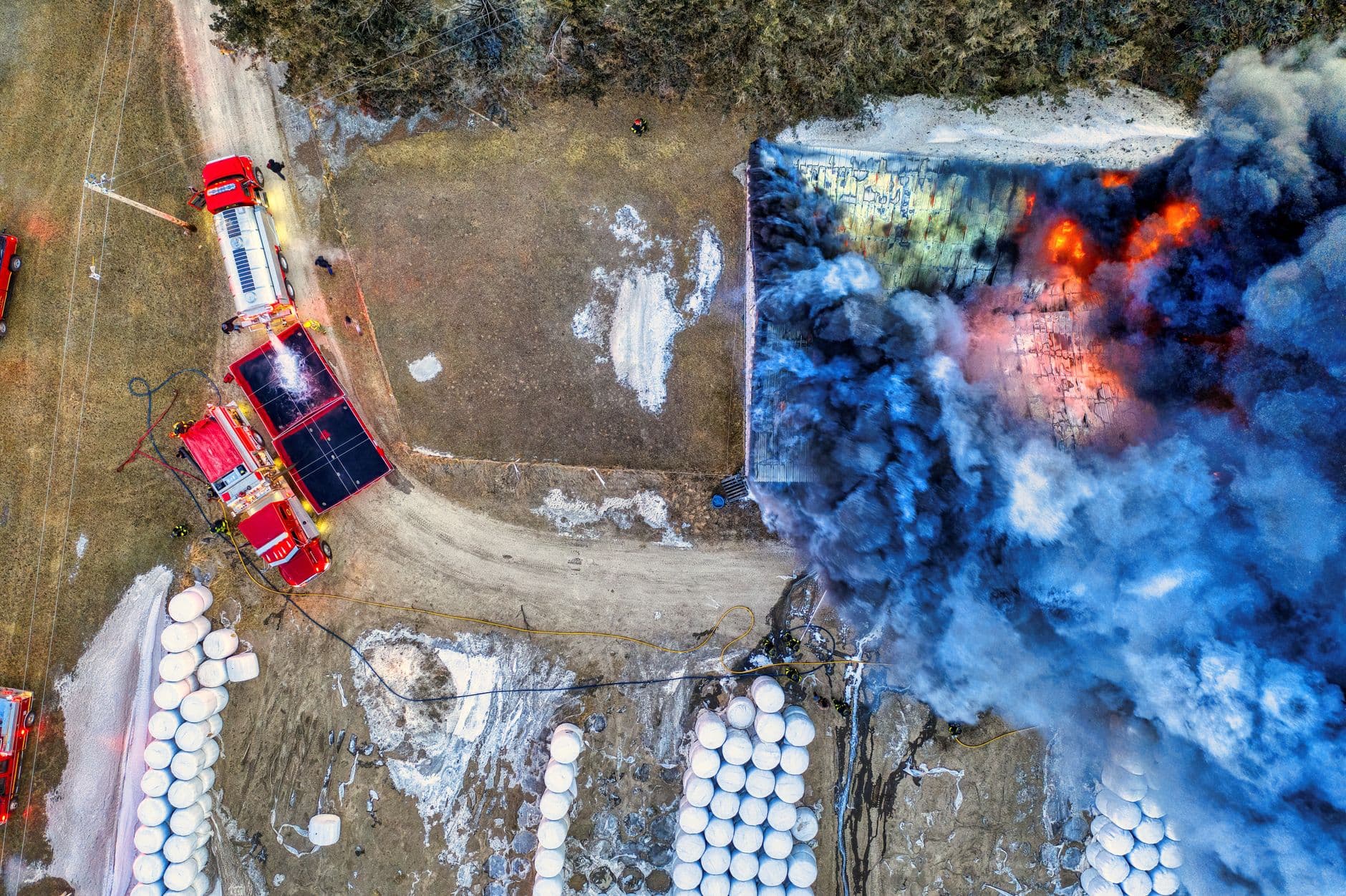 Image illustrating: Firefighters at a smoky warehouse near a Belgian regional border, with residents (editorial)