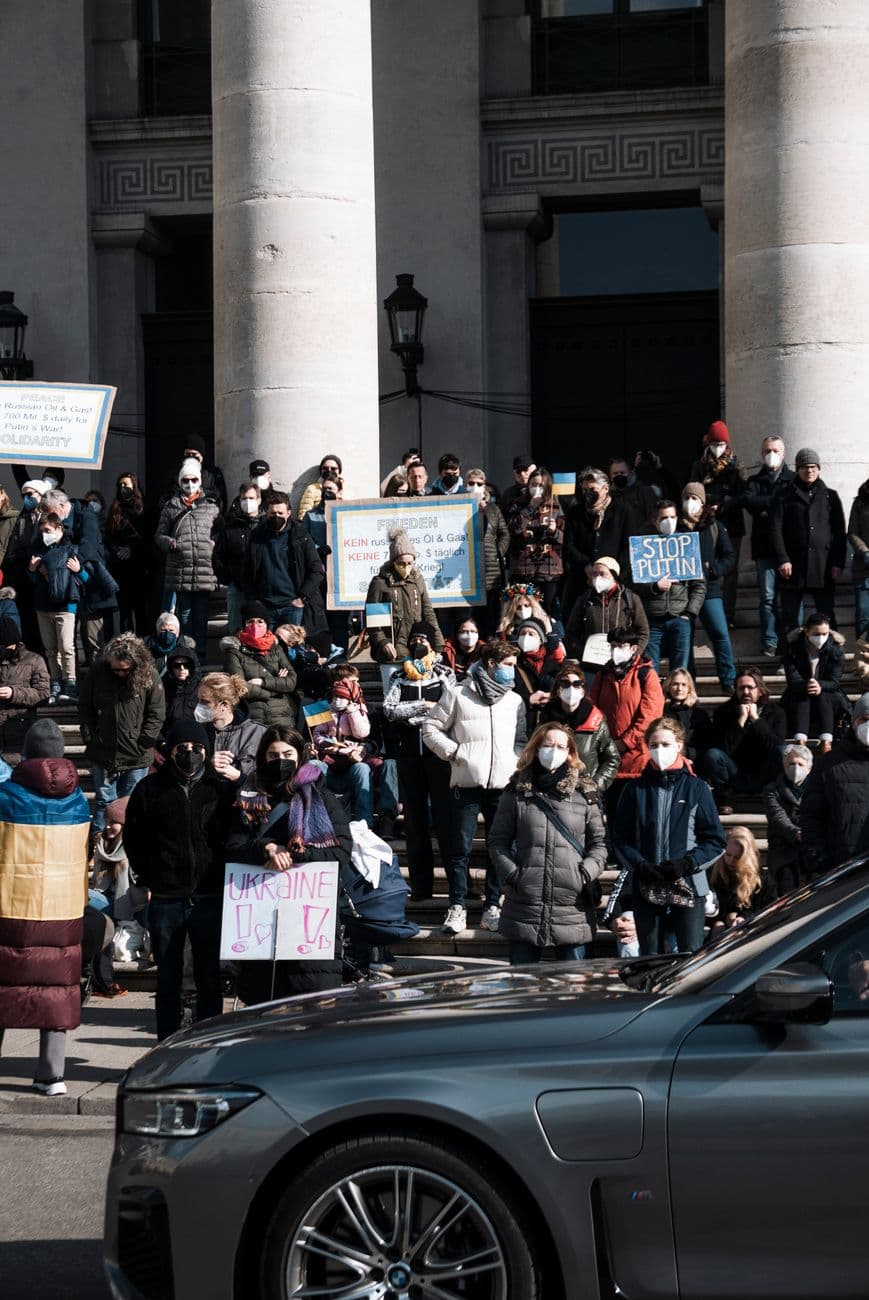 Image illustrating: Teachers gathered in Liège outside a school or public building with protest sign (editorial)
