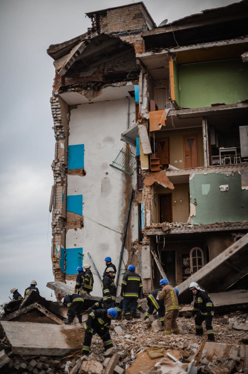Image illustrating: Ukrainian rescue workers after a Russian missile or drone strike, with EU and Be (editorial)